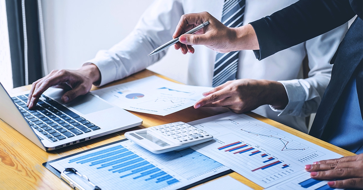 Duas pessoas estudando como reduzir custos logísticos de uma empresa